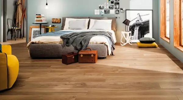 Camera da letto moderna con pavimento effetto legno, che ricorda i materiali lapidei per la sua resistenza e bellezza.