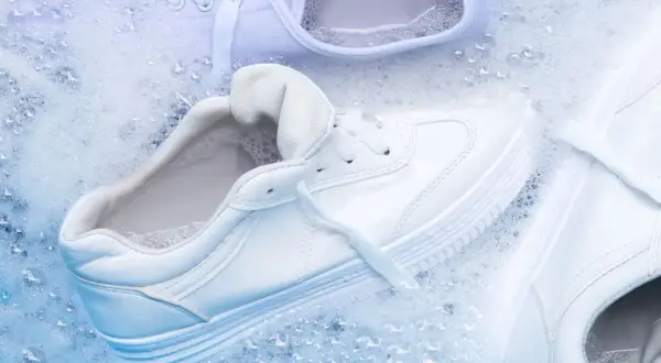 Come lavare le all star bianche: scarpe immerse in acqua e schiuma per un lavaggio impeccabile.