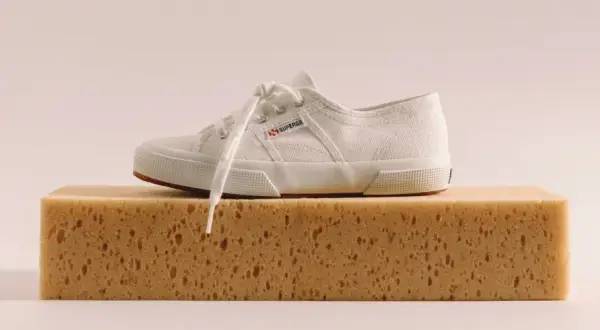 Scarpa bianca Superga su una spugna, pronta per lavare Superga in lavatrice.