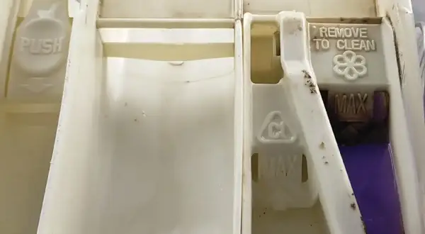 Cassettino detersivo lavatrice sporco, con residui di ammorbidente viola. La lavatrice non prende detersivo a causa di ostruzioni.
