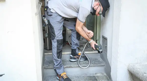 Tecnico con attrezzatura per pulizia a vapore, pronto a dimostrare come sbiancare la pietra e riportarla al suo antico splendore.