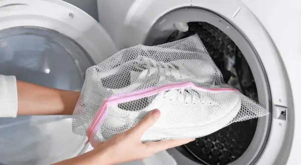 Come lavare le scarpe da trekking in lavatrice: inserisci le scarpe in una sacca a rete prima di metterle nell'oblò.