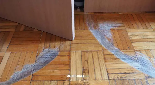 Parquet rovinato, pronto per il rinnovo. Segni evidenti di usura e graffi sul legno, in attesa di nuova vita.