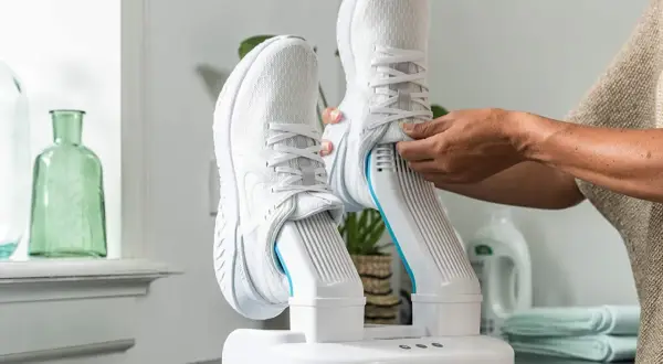 Come asciugare le scarpe da ginnastica: un dispositivo bianco con due stivali da corsa bianchi inseriti, pronto per l'asciugatura.