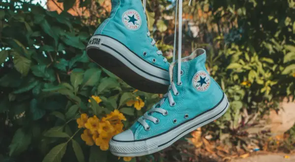 Scarpe All Star azzurre appese, pronte per essere lavate in lavatrice.