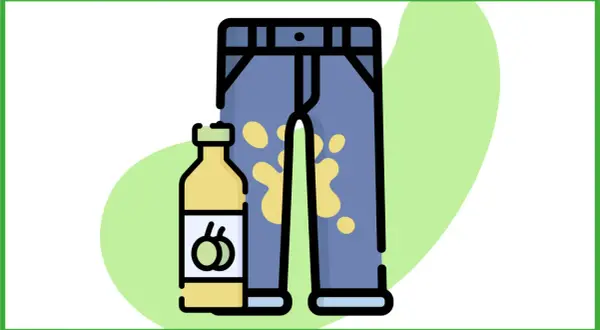 Un flacone di detersivo accanto a un paio di pantaloni con una macchia d'olio gialla.