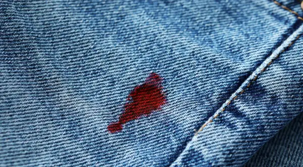 Macchia rossa su jeans blu, un problema comune per chi cerca come togliere le macchie di ciclo.