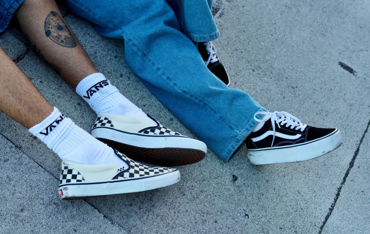 Due paia di Vans, una a scacchi e una nera con zeppa, pronte per essere lavate in lavatrice.