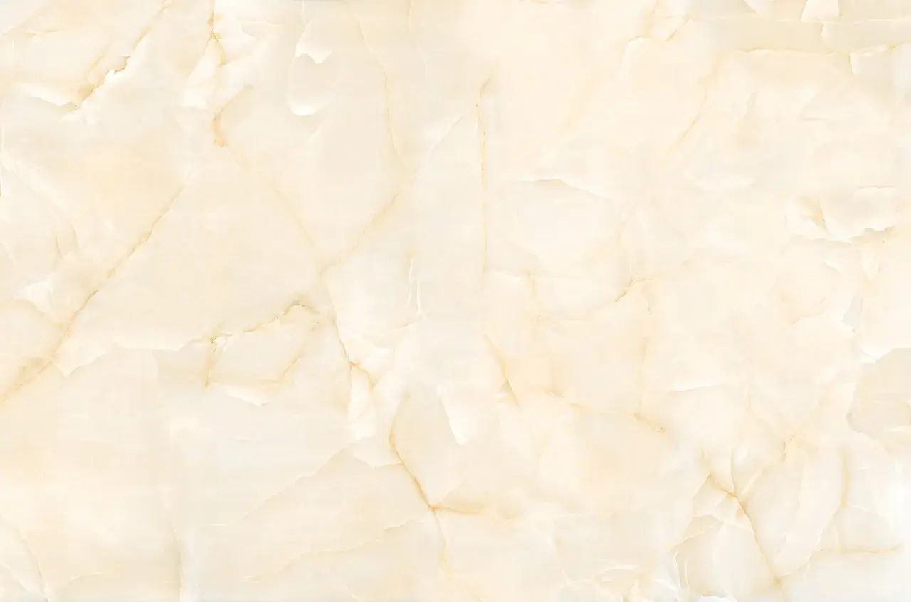 Superficie in marmo beige con venature dorate, ideale per scoprire come pulire il marmo poroso e mantenerlo splendente.