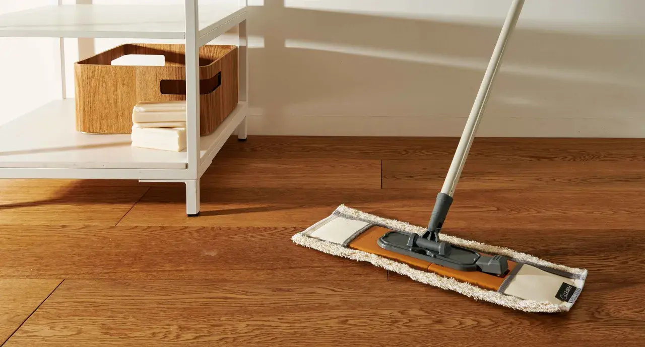 Mocio pronto per pulire pavimento marmo molto sporco. Sulla mensola, una cesta in legno e saponi.