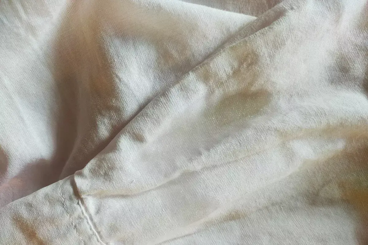 Tessuto chiaro con macchie, forse necessita di un detersivo per togliere la muffa dai tessuti.
