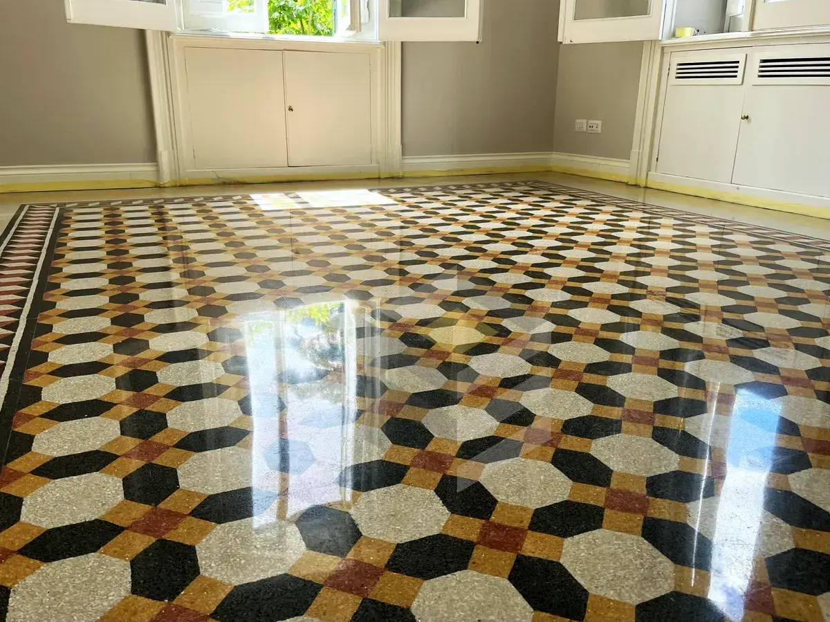 Pavimento in graniglia con motivo geometrico dai colori vivaci, reso brillante dalla lucidatura.