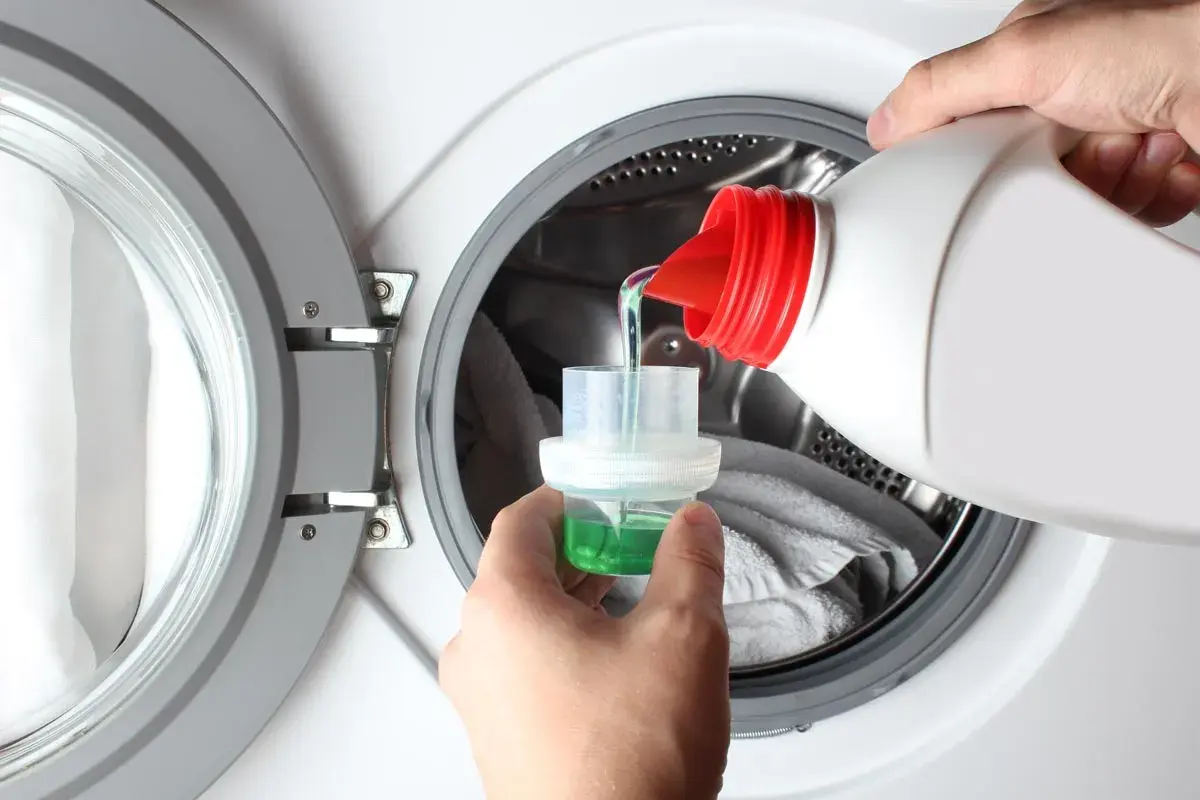 Versare il detersivo liquido nella capsula dosatrice, per sapere quanto detersivo mettere in lavatrice.