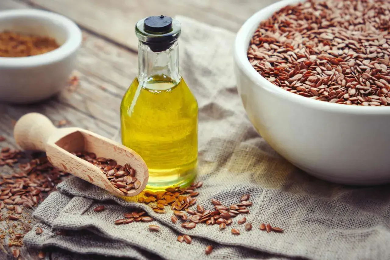 Olio di lino per pavimenti in graniglia, con semi sparsi e una ciotola piena.