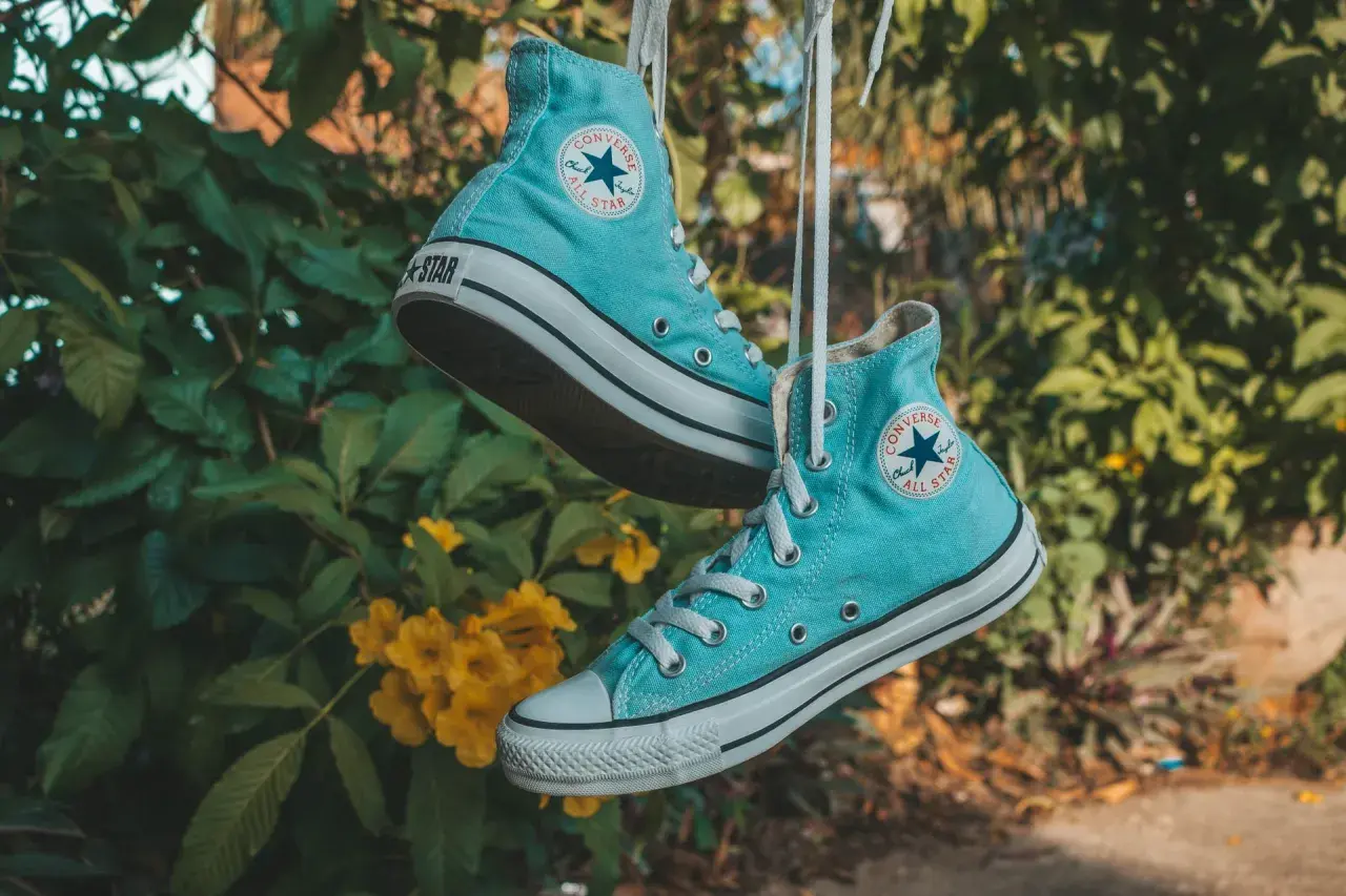 Scarpe All Star azzurre appese, pronte per essere lavate in lavatrice.