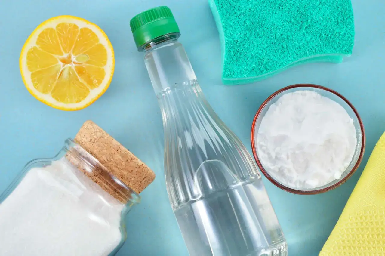 Ingredienti per detersivi fatti in casa: limone, aceto, bicarbonato e spugna. Pulizia ecologica e profumata.