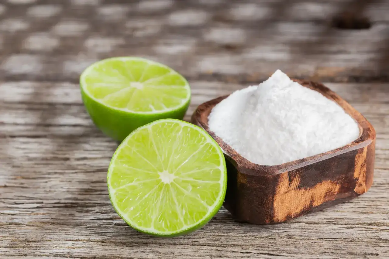 Mezzo limone verde brillante e una ciotola di polvere bianca, forse per chi soffre di acido citrico allergia.