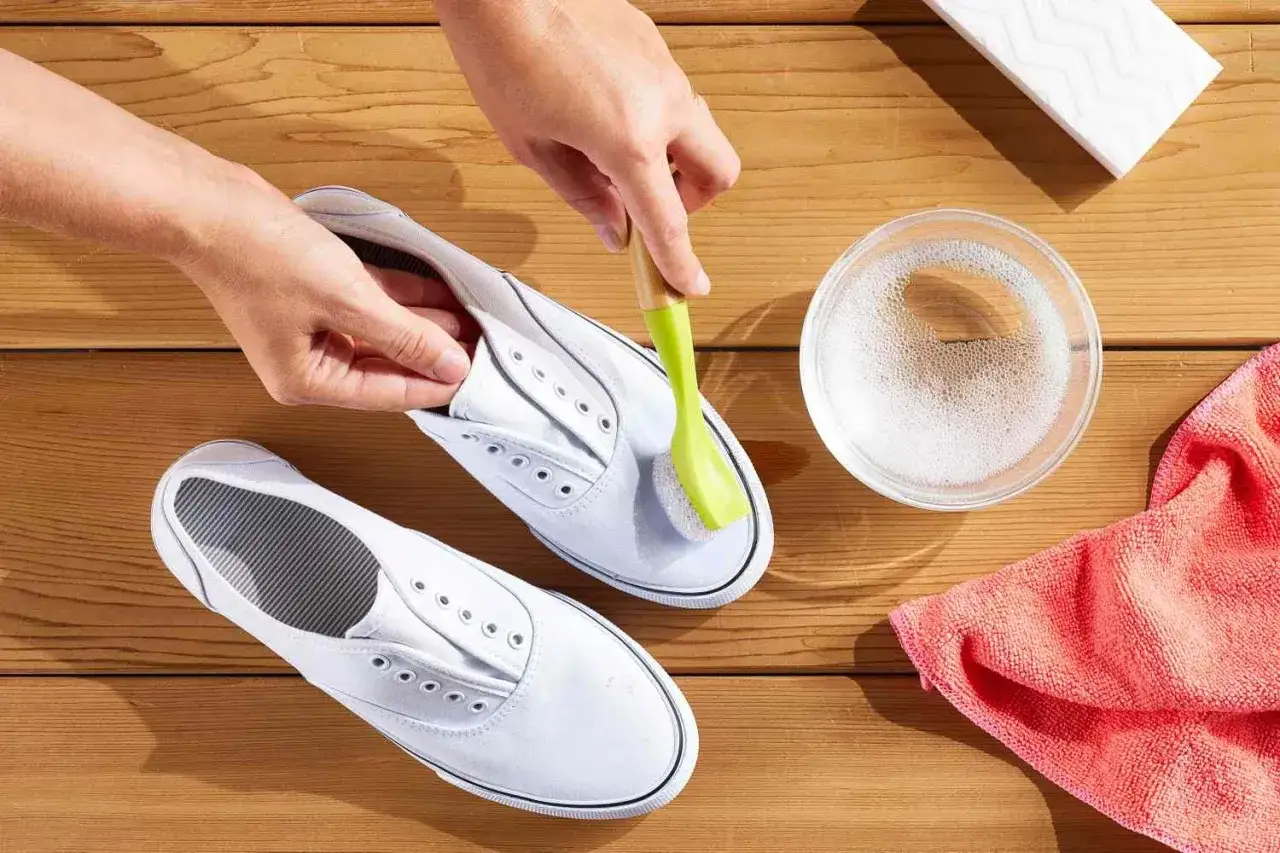 Mani che puliscono le converse bianche con una spazzola e acqua saponata. Ecco come lavare le converse bianche per farle tornare come nuove.