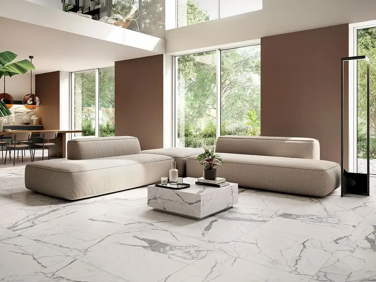 Soggiorno moderno con divani beige e un tavolino in uno dei tipi di marmo più eleganti, il Calacatta.