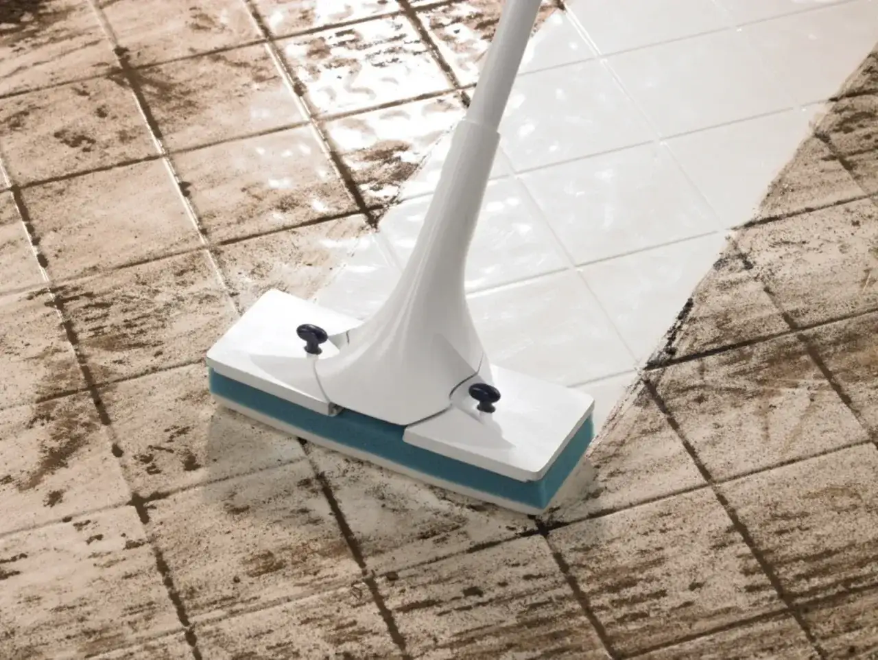 Un mocio pulisce un pavimento di piastrelle sporche, lasciando una scia bianca e pulita. L'acqua ossigenata è un ottimo alleato per pulire i pavimenti.