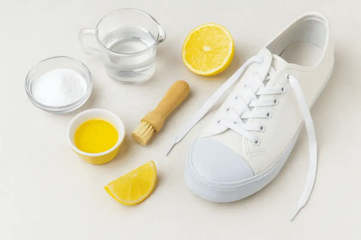 Set per pulire le scarpe: bicarbonato, limone, acqua, spazzola e una scarpa bianca. Ideale per capire come lavare le scarpe dentro.