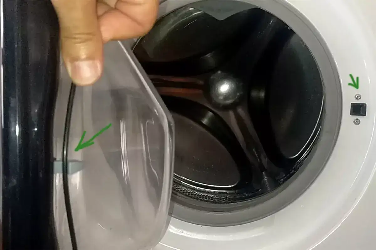 La lavatrice non parte. La porta trasparente è aperta, mostrando il cestello. Una freccia verde indica un punto di aggancio.