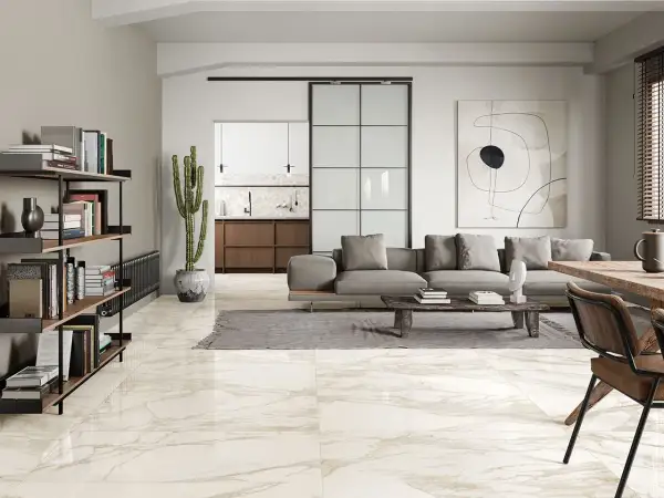 Pavimenti in splendidi tipi di marmo che riflettono la luce in un soggiorno moderno con divano grigio e libreria.