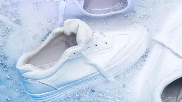 Come lavare le all star bianche: scarpe immerse in acqua e schiuma per un lavaggio impeccabile.