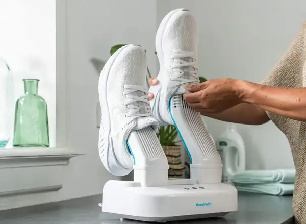 Come asciugare le scarpe da ginnastica: un dispositivo bianco con due stivali da corsa bianchi inseriti, pronto per l'asciugatura.