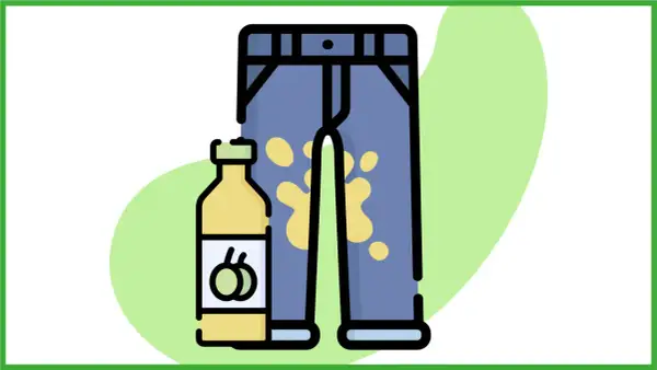 Un flacone di detersivo accanto a un paio di pantaloni con una macchia d'olio gialla.