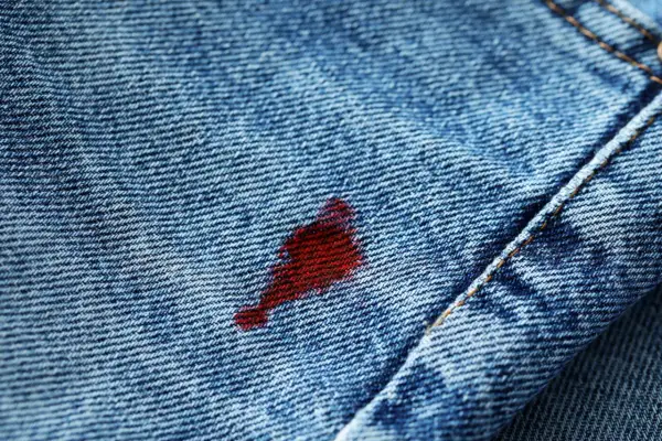 Macchia rossa su jeans blu, un problema comune per chi cerca come togliere le macchie di ciclo.